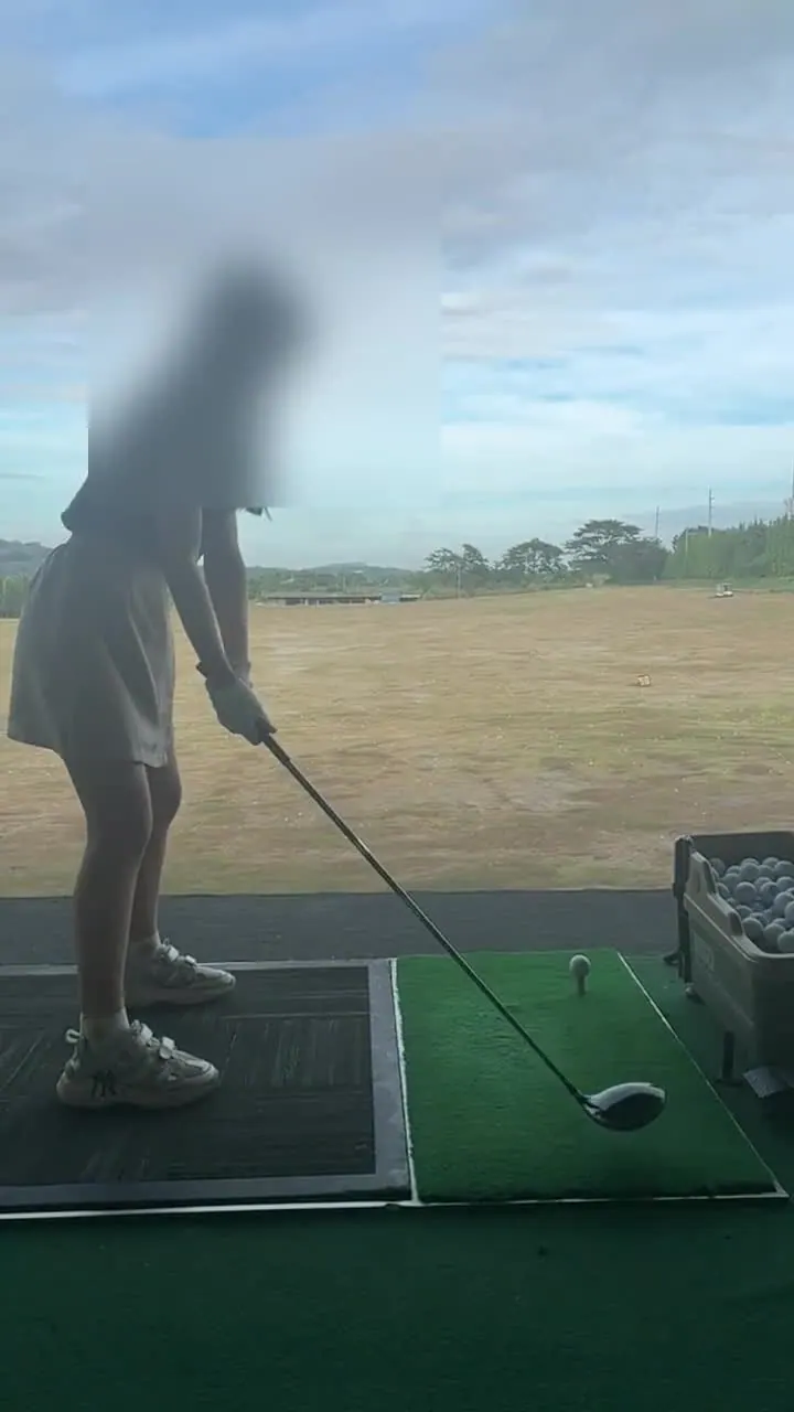 Student working on swing form at the practice range