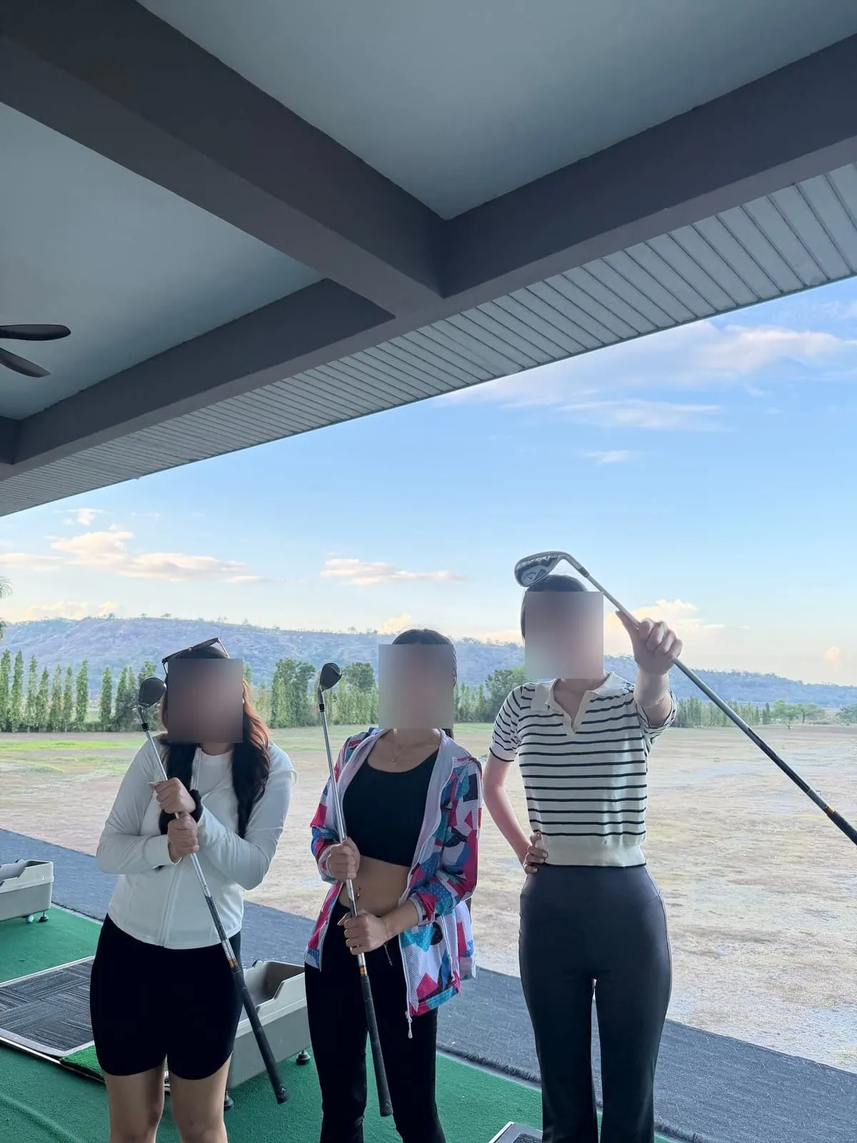 Students with clubs at the driving range before a lesson