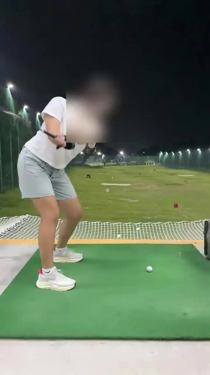 Evening driving-range lesson under the floodlights