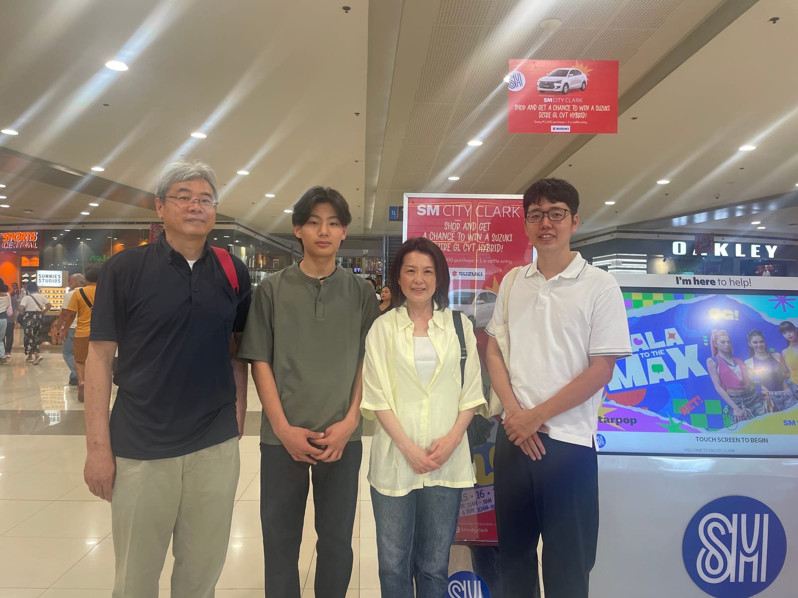SM City Clark のモール内で、日本人スタッフや他の学生と並んで写る様子