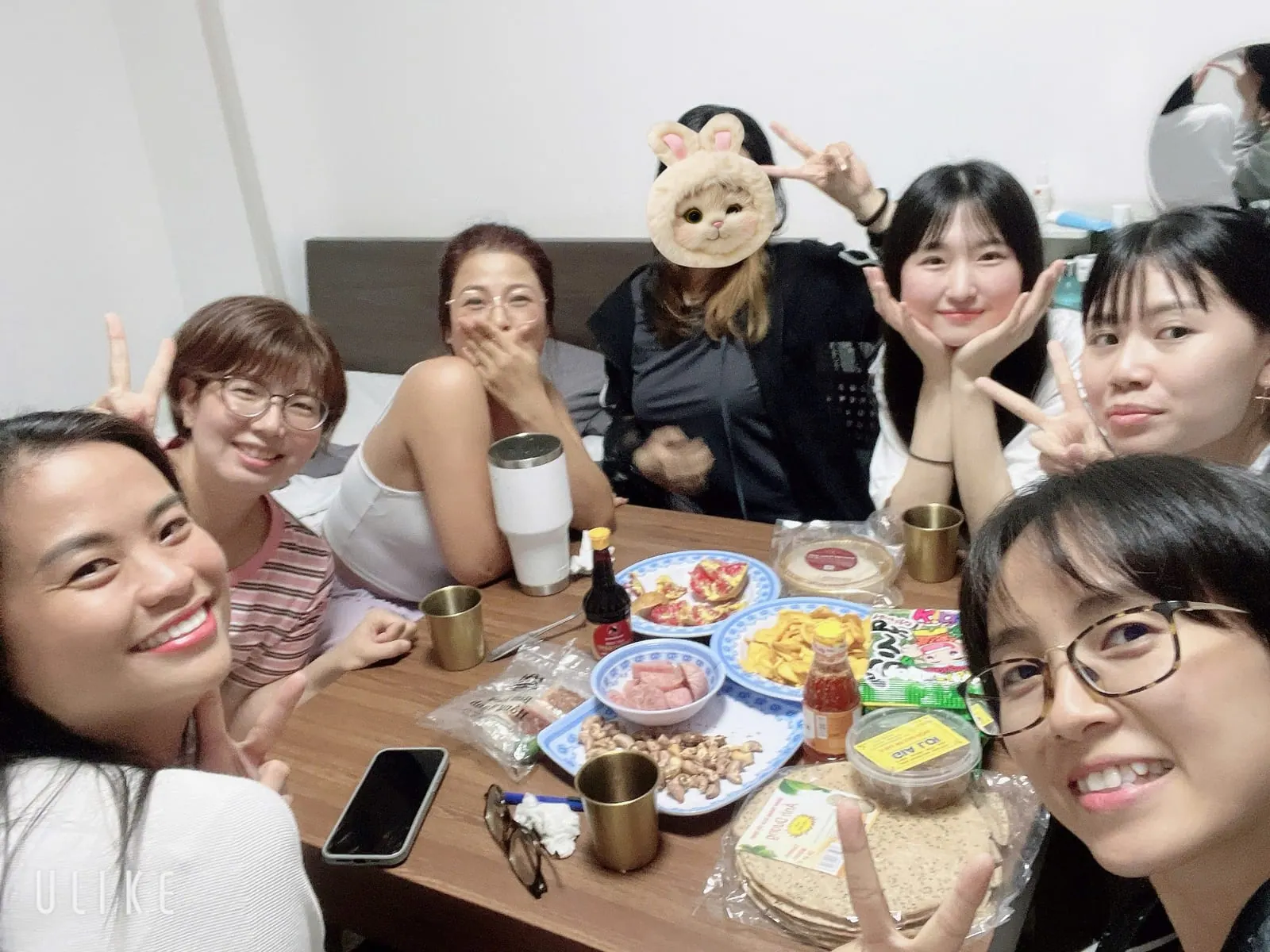 A shared dinner in a dorm room with dishes brought by each student
