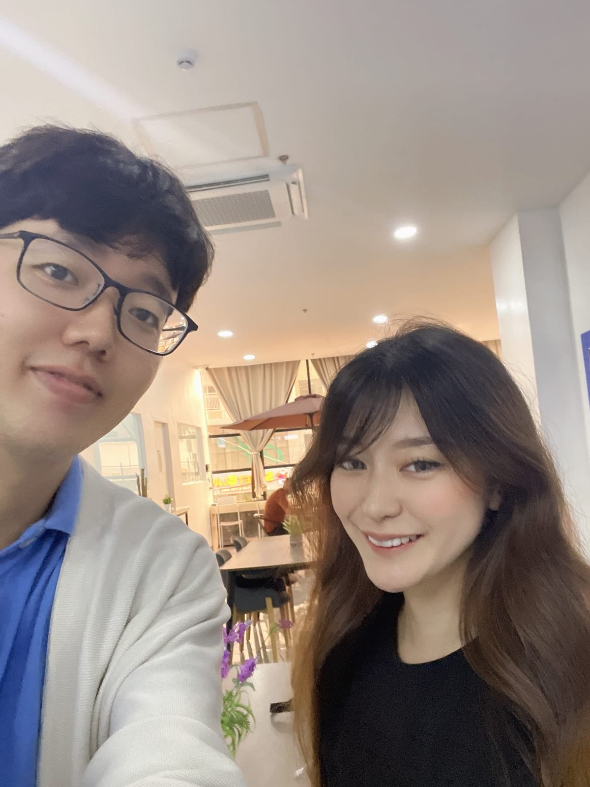 Karin Hasegawa smiling beside her teacher in the campus lounge