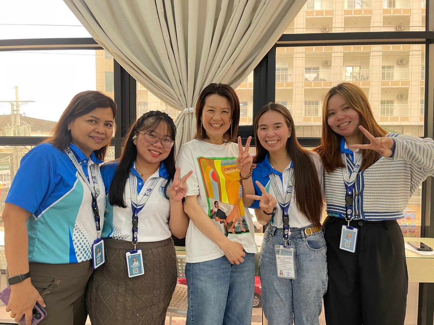 Momoe Yamada smiling alongside Talk Academy staff members
