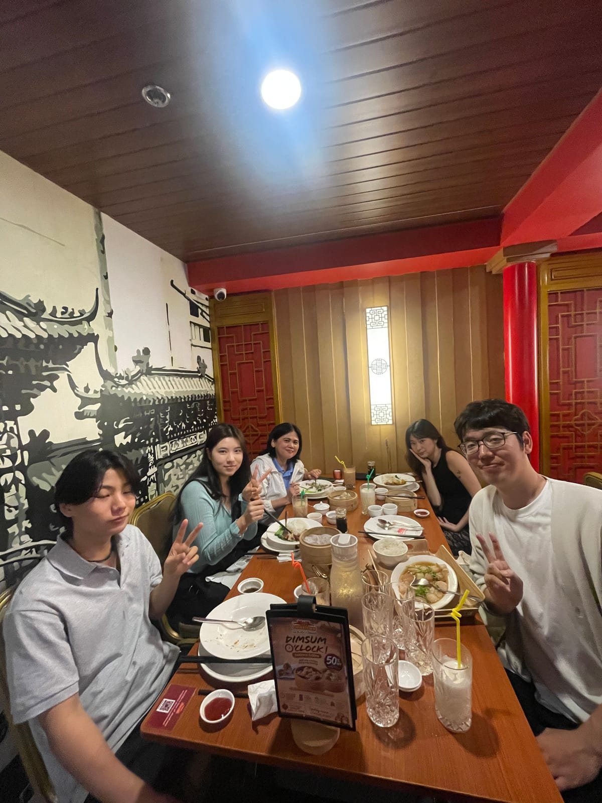 Taiyo Nishimura at a long table in a Chinese restaurant with friends his age from several countries