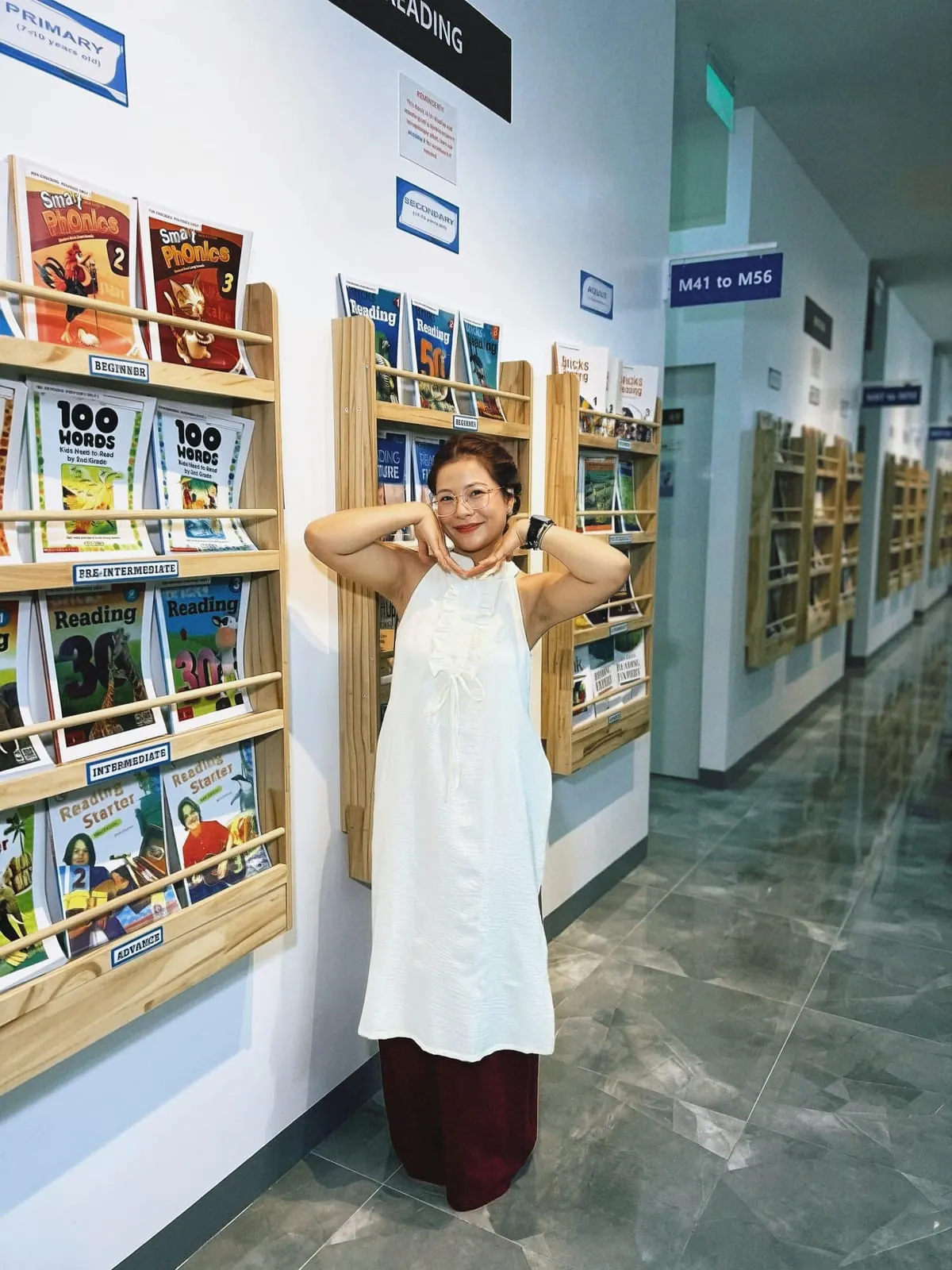 Thu Thao beside the textbook shelves in the school corridor