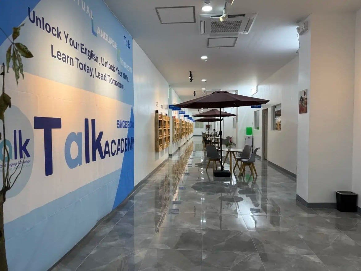 Um corredor da escola com Unlock Your English pintado na parede