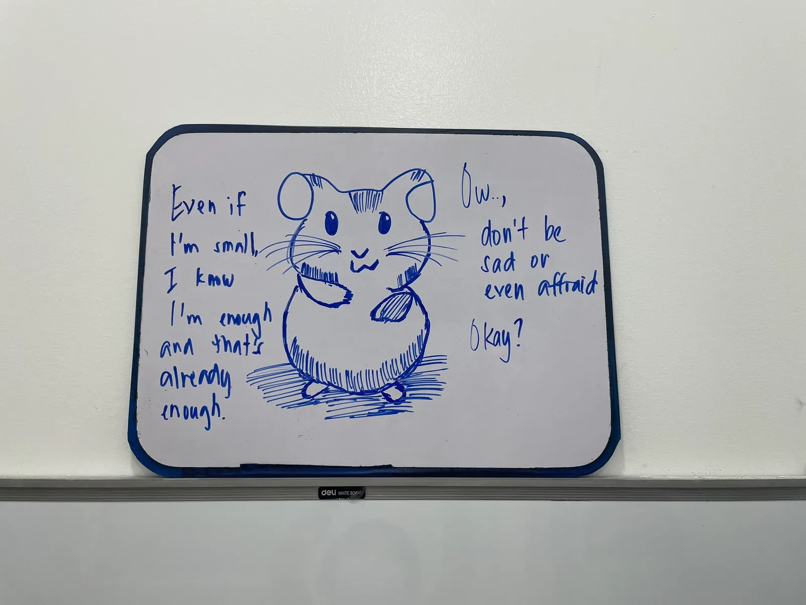 Sınıftaki beyaz tahtaya çizilmiş bir hamster ve yanında Even if I'm small, I know I'm enough yazısı