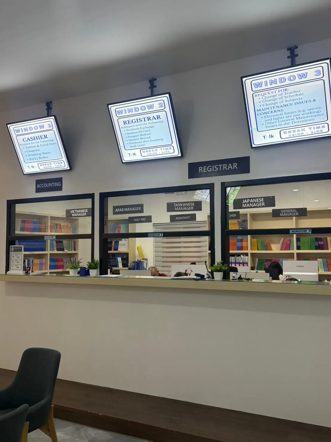 The school's front counter windows, divided by function and language