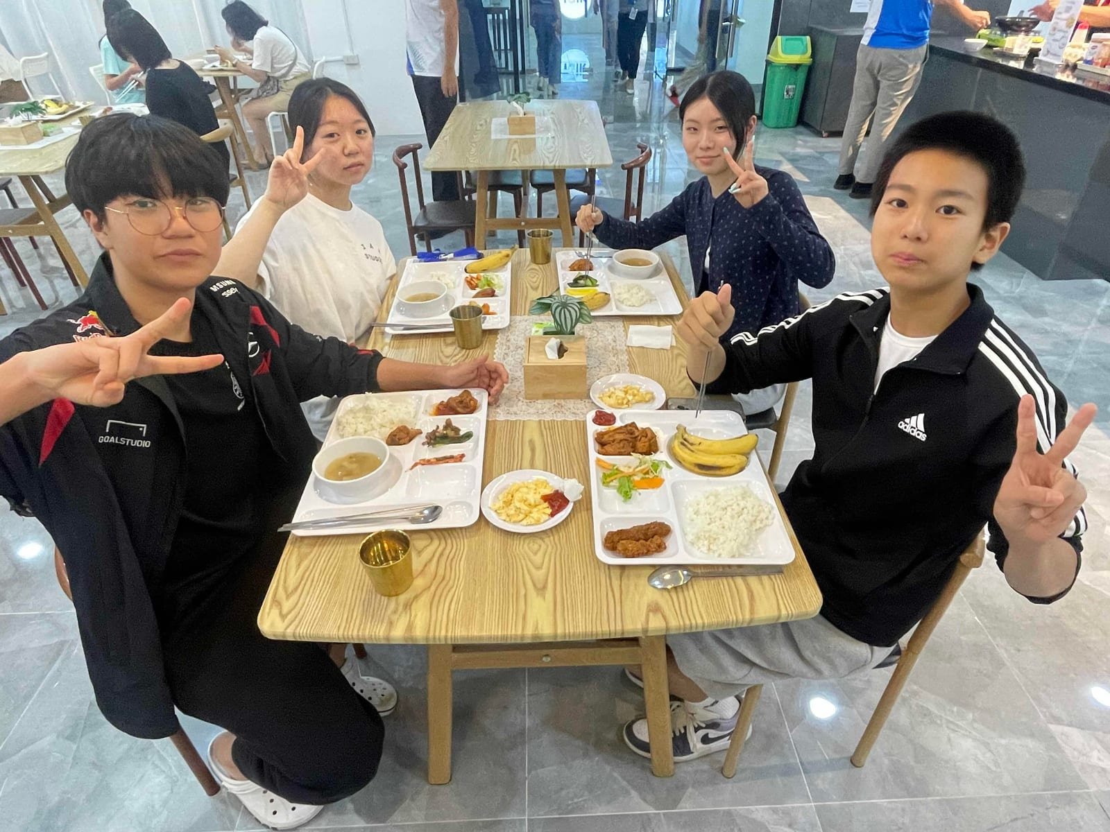 식당 테이블에서 트레이에 담긴 식사를 앞에 두고 앉은 학생들